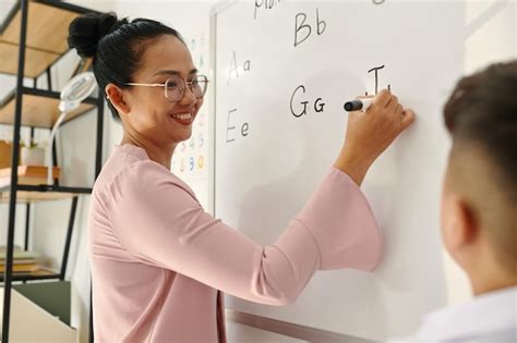 Premium Photo | Teacher writing letters on whiteboard