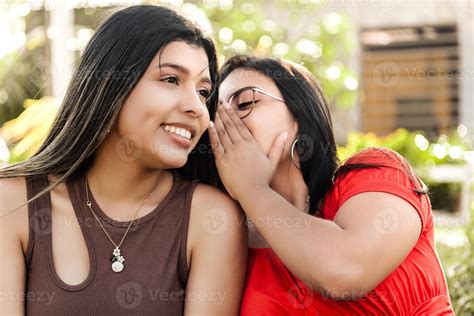 Two best friends telling secrets, young woman whisper secret a friend