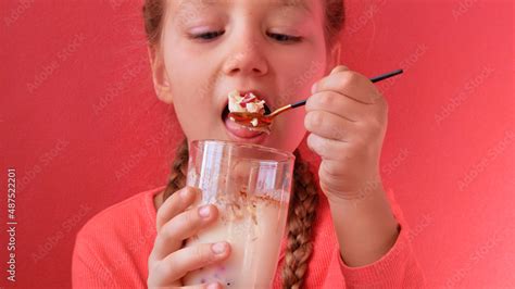 Child eating yogurt jelly pink background. Dairy product diet ...