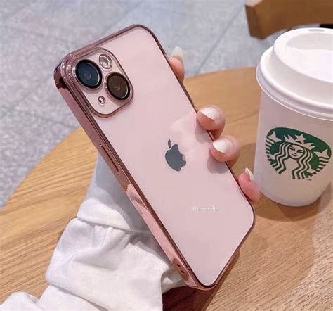 a person holding an iphone in their hand next to a cup of coffee and a ...