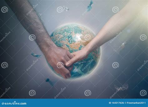 Мужчина и женщина, держащие руки на заднем плане планеты Земля ...