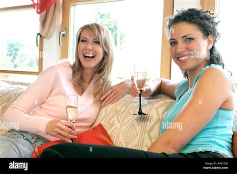 Zwei Frauen trinken zusammen ein Glas Sekt, two women drinking ...