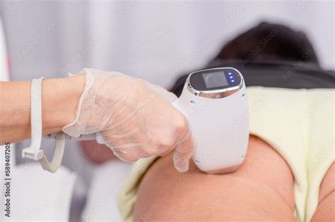 Professional beautician removes hair on female buttocks of senior woman ...