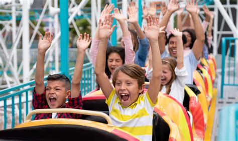 Happy group of people having fun in a rollercoaster at an amusement park - Catholic Digest