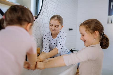 Three little sisters washing hands in a bathroom, morning routine