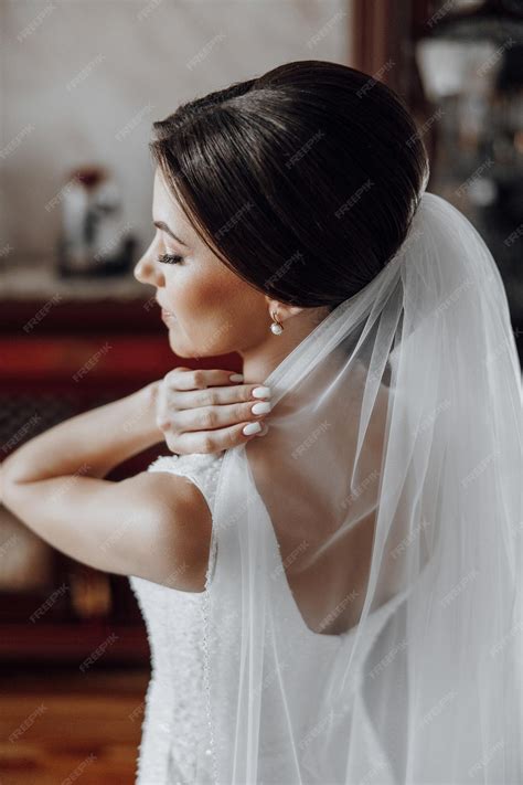 Premium Photo | A woman in a wedding dress is wearing a veil with a