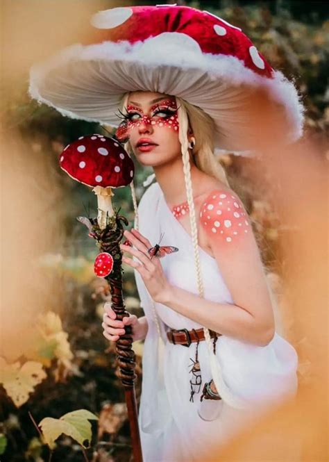 a woman in white dress and red hat holding a mushroom