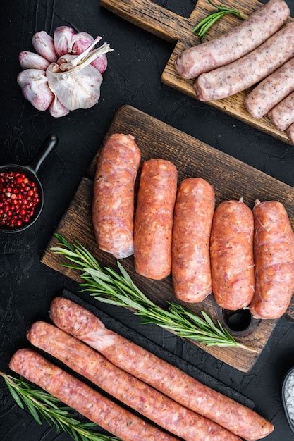 Premium Photo | Raw sausages on dark background