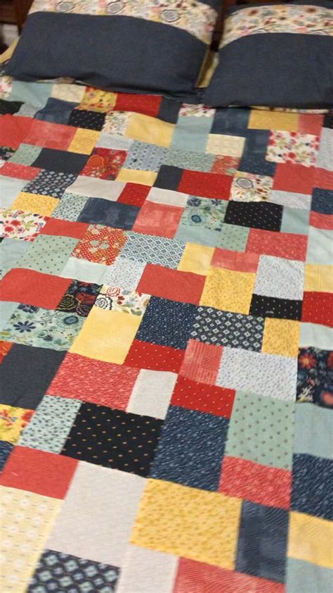 a bed with a colorful quilt on top of it