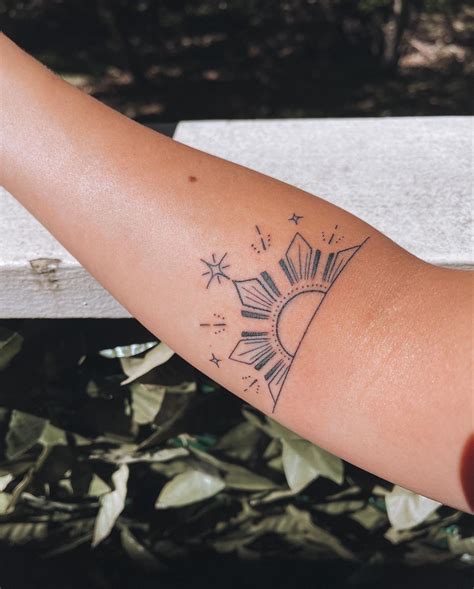 a woman's arm with a tattoo on it that has the sun and stars