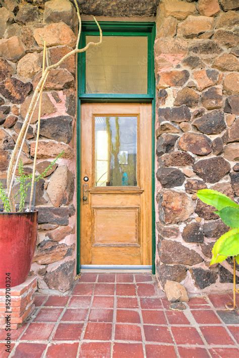 Wooden front door with glass panel and transom window in between a ...