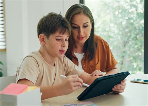 Mom helping son with schoolwork on tablet