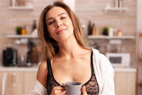 Seductive housewife relaxing during breakfast sitting in modern cozy