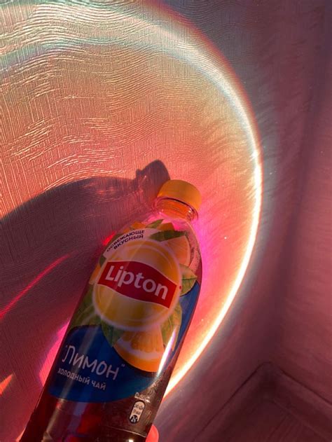 a bottle of liquid sitting on top of a white chair with a pink light ...
