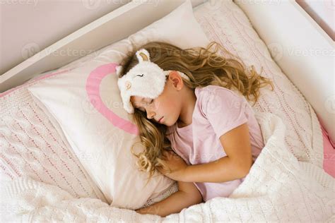 Little girl is sleeping in her bed on a pillow. Sweet peaceful sleep of