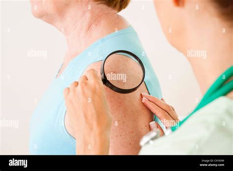 Dermatologen, die Untersuchung eines Patienten mit einer Lupe ...