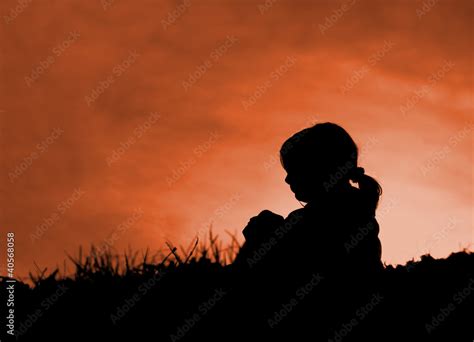 Alone little girl sitting on meadow in sunset - silhouette Stock Photo ...