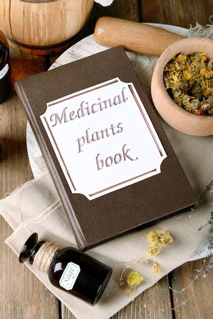 Premium Photo | Medicinal plants book with dried herbs and bottles on ...