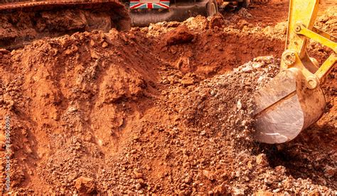 Backhoe digging soil at construction site. Bucket of backhoe digging ...