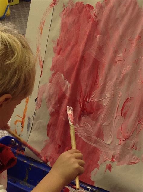 Mixing red and white to make different shades of pink on the easel