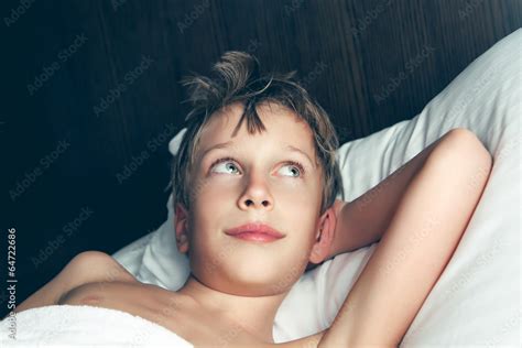 Beautiful boy lying in bed dreaming Stock Photo | Adobe Stock