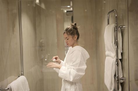 Woman Holding Gray Hair Dryer and Wearing White Bathrobe · Free Stock Photo