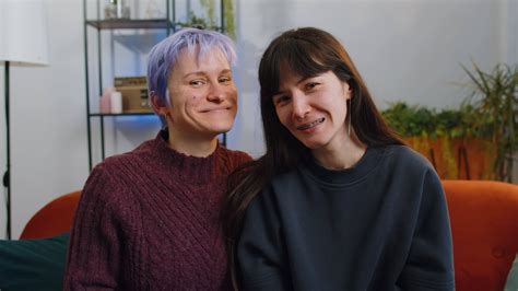 zwei jung Lesben lgbt Frauen Familie Paar zeigen Engagement Ringe nach