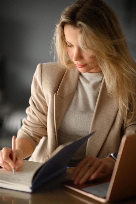 With a cheerful expression, she balances work on her laptop and notes