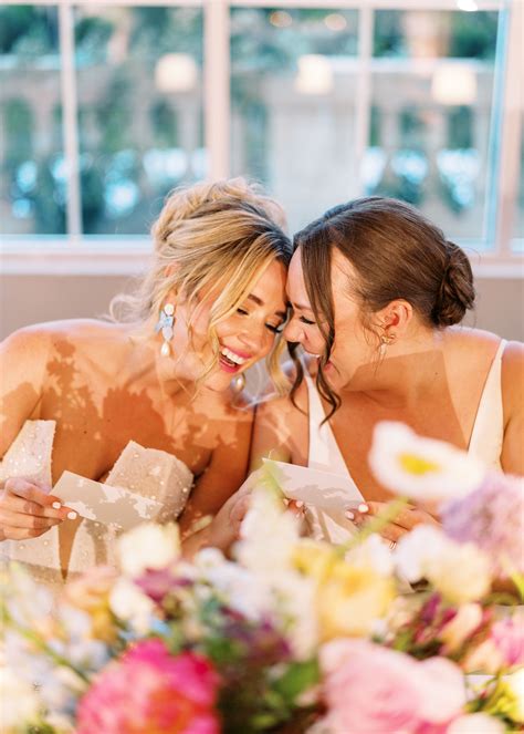 Brides Share Notes at Floral Sweetheart Table During Their Reception