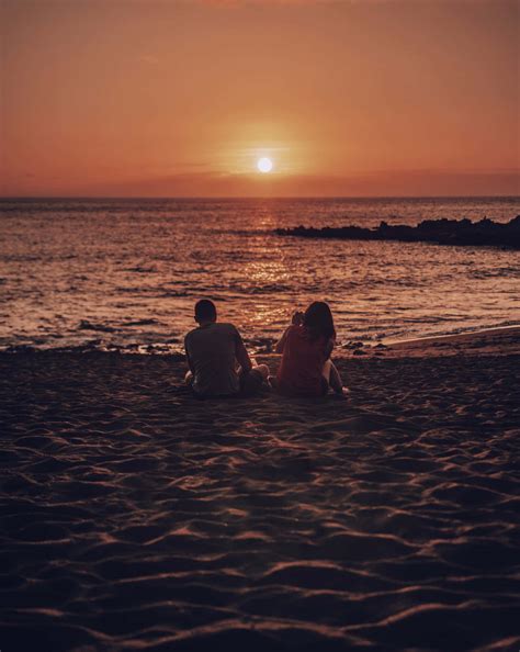 Download Couple At Beach Sunset Photograph Wallpaper | Wallpapers.com