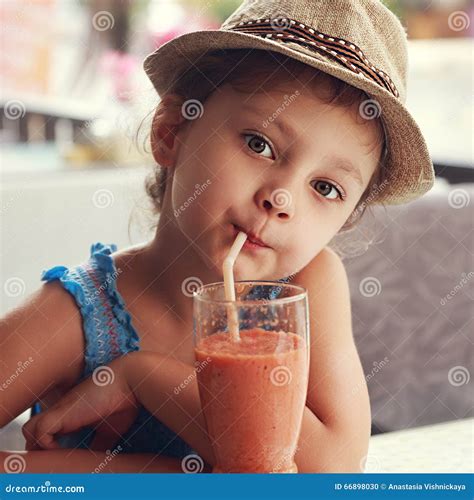 Девушка ребенк потехи милая выпивая здоровый сок Smoothie в остатках ...