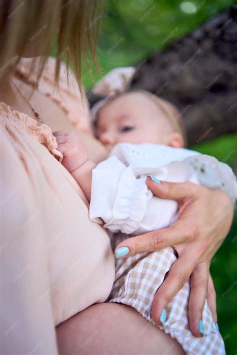 Premium Photo | Beautiful mother is breastfeeding her baby girl in the
