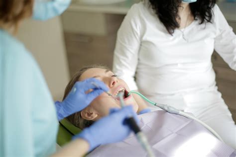 Crop dentist in gloves treating teeth of patient · Free Stock Photo