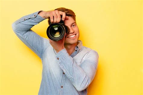 Веселый молодой человек с профессиональной камерой, сфотографироваться ...