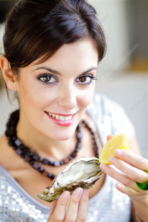 Woman eating oyster - Stock Image - C032/6209 - Science Photo Library