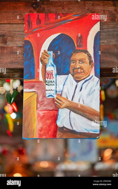The painting of a man holding a Tequila bottle inside a shop in Holbox
