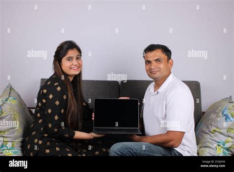 Smiling young couple Hold laptop computer with blank empty screen