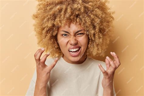 photo outraged young woman  curly bushy hair gestures