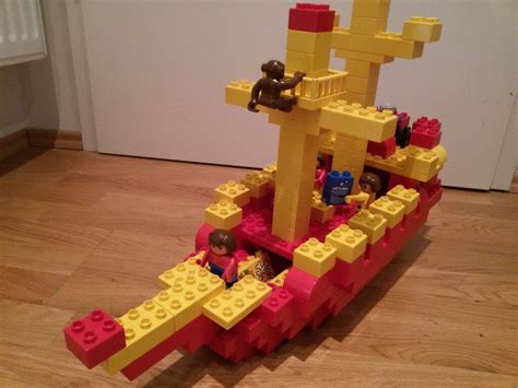 there is a lego boat made out of yellow and red bricks on the floor ...