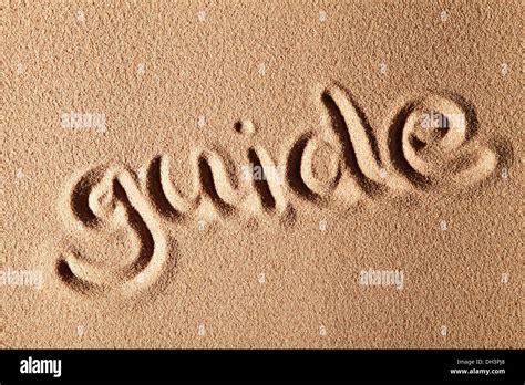 The word guide, written in sand Stock Photo - Alamy