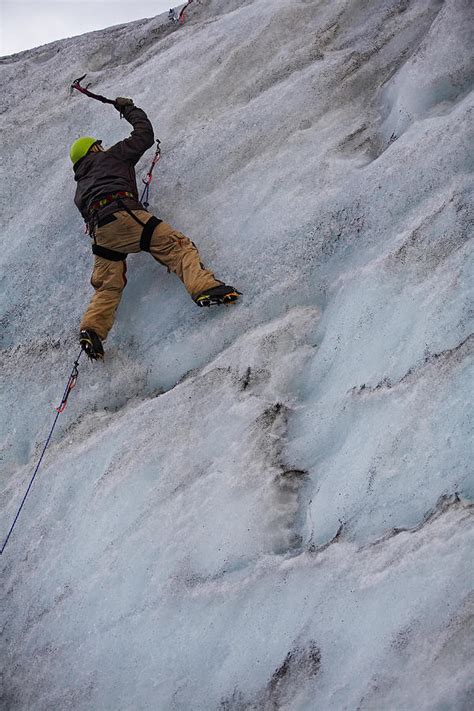 Young Man Climbing Ice Wall At Solheimajokull Glacier In Iceland ...