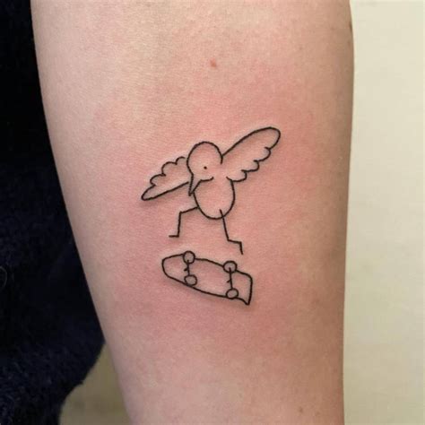 Bird skateboarding tattoo on the inner forearm.