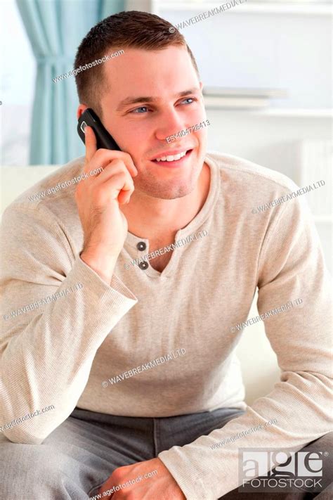 Portrait of a man making a phone call while sitting on a sofa, Stock ...