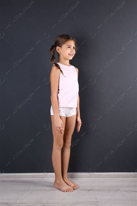 Cute little girl in underwear near dark wall: Stock Photo | Download on