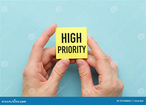 high priority text written  sticky  hands  blue background stock