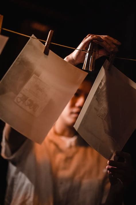 Man Handing Developed Pictures in a Darkroom · Free Stock Photo