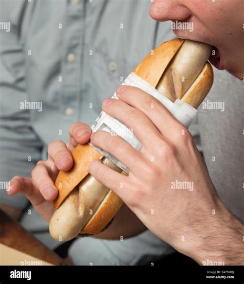 Man eating sausage sandwich in a restaurant Stock Photo - Alamy