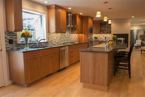 a kitchen with wooden cabinets and an island in the middle of it is lit ...