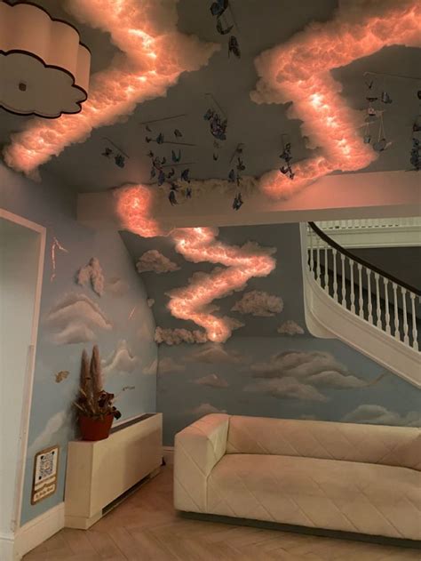a living room filled with furniture and clouds painted on the ceiling ...