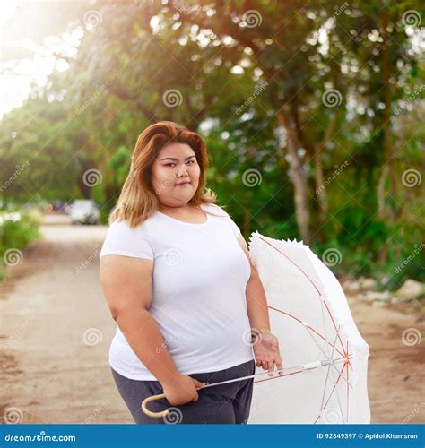 Asian Beautiful Fat Woman with Umbrella in the Garden. Stock Image